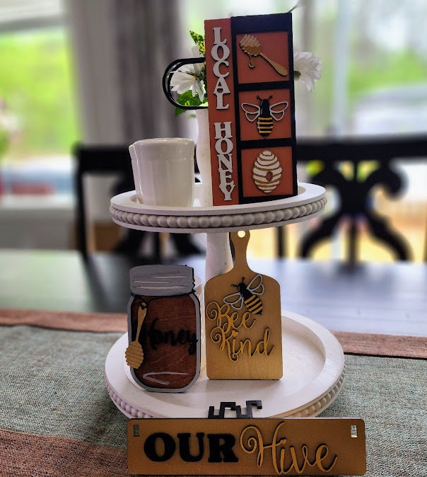 Wooden wagon insert featuring local honey and bee-themed decorative blocks on a white two-tiered stand
