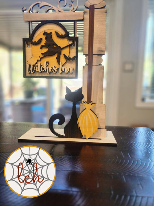 Wooden Halloween decoration featuring a witch, black cat, and broom with a spooky design