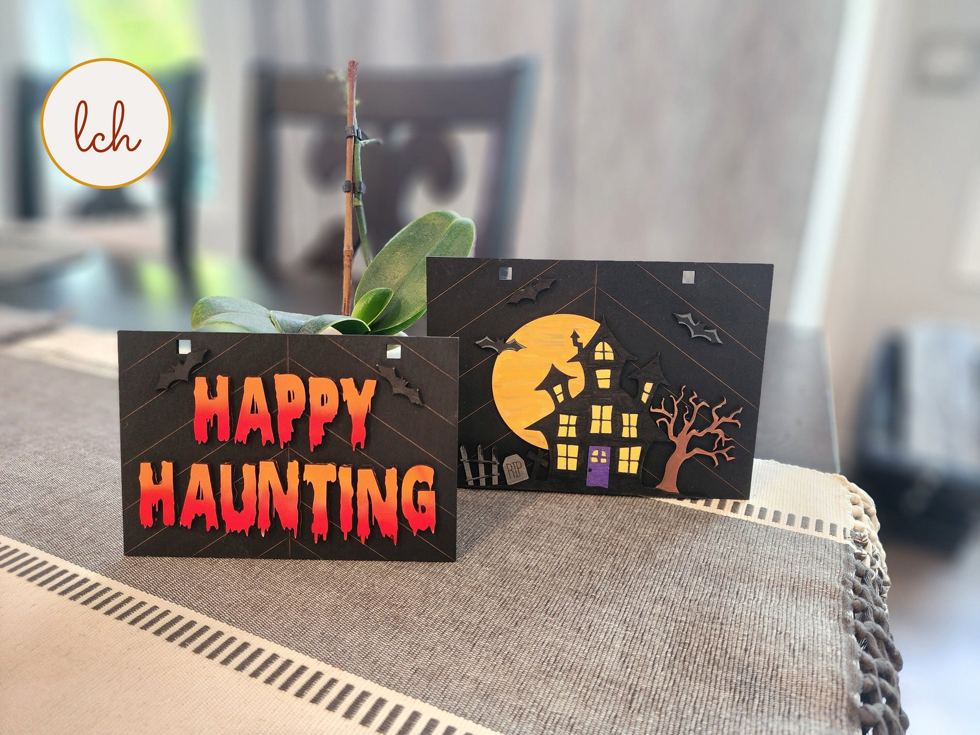 Halloween wooden ladder picture frame with spooky Happy Haunting and haunted house designs on table