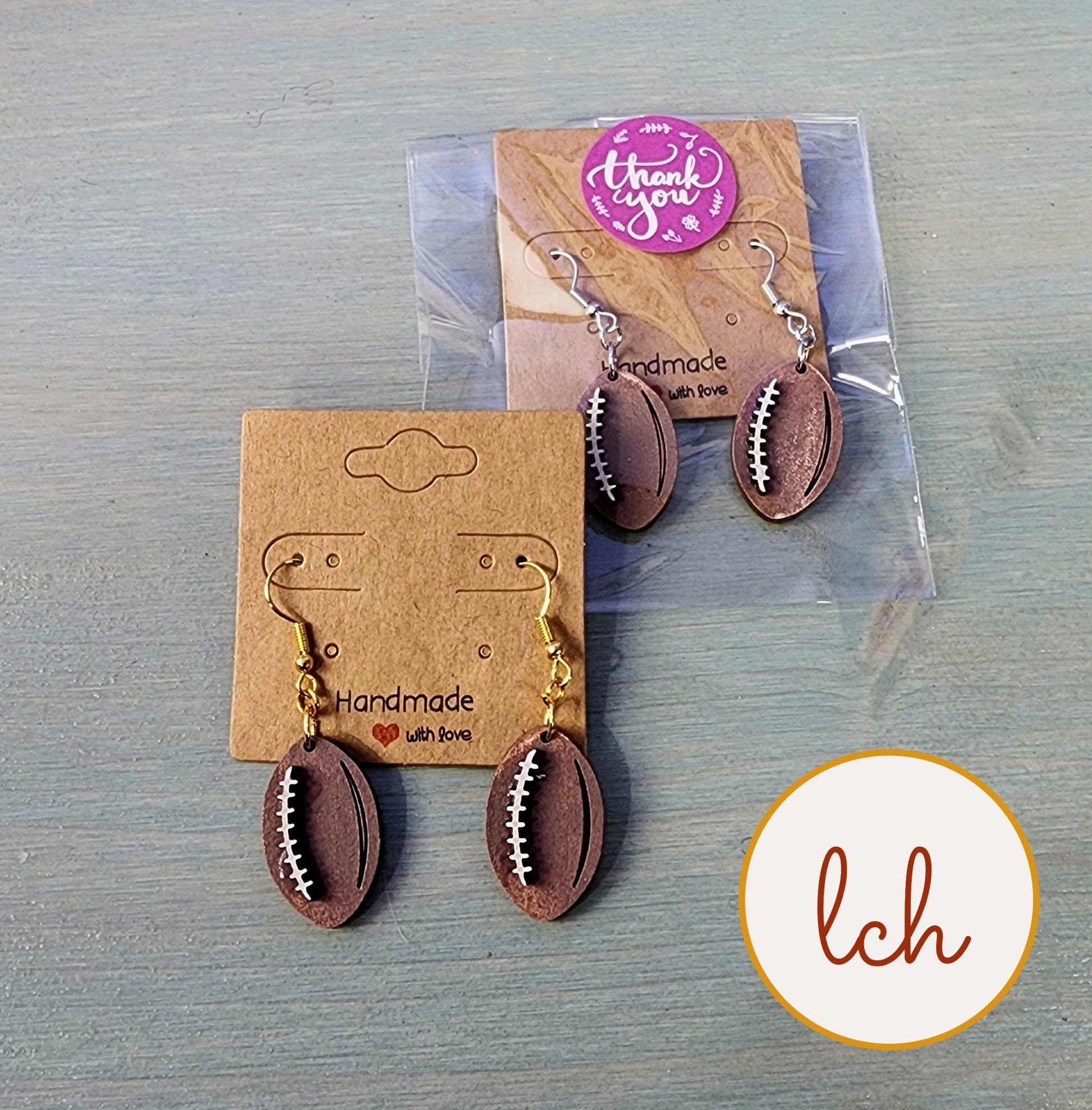 Hand painted wooden earrings shaped like footballs with gold and silver hooks by My Store