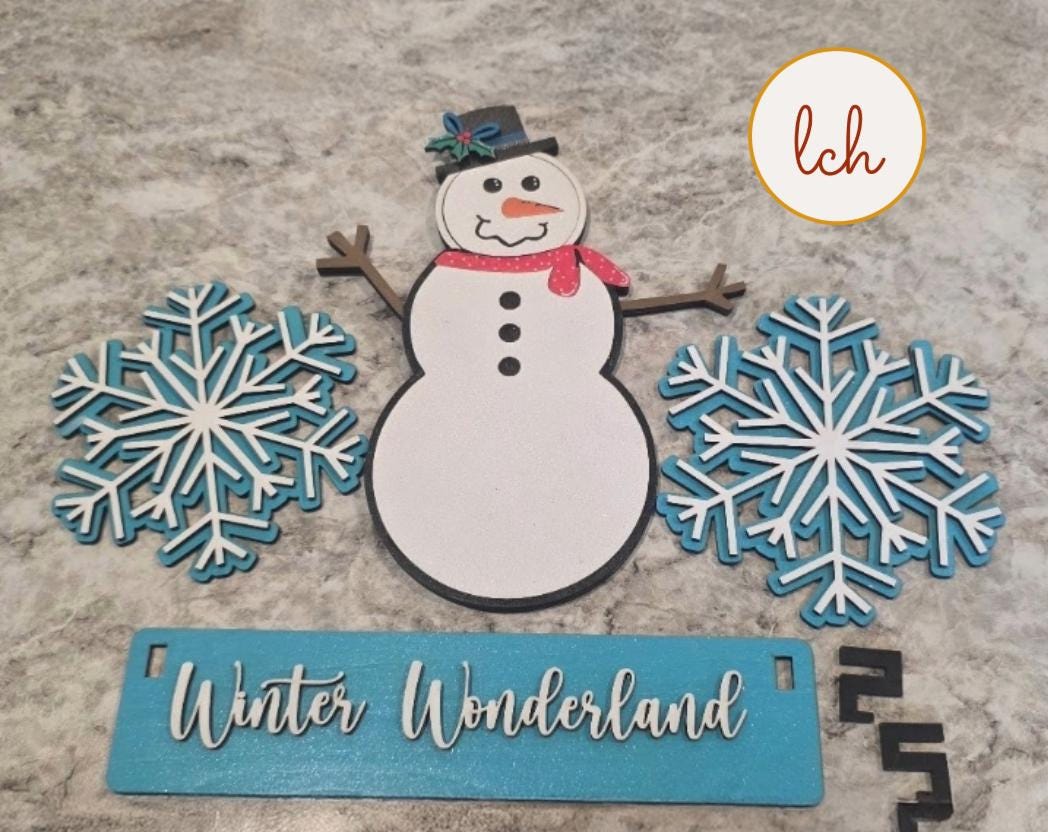 Handcrafted snowman decor for shelves featuring a wooden snowman, blue snowflakes, and Winter Wonderland sign