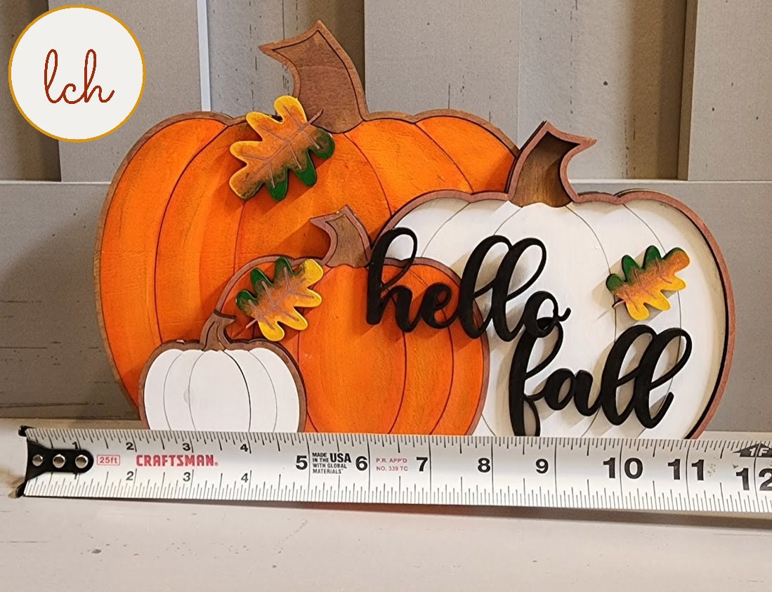 Decorative wooden pumpkins with hello fall sign in orange and white colors for autumn decor