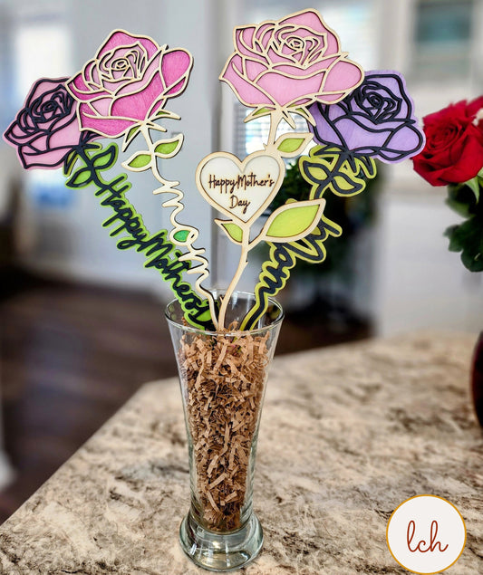 Mother's Day wooden gifts featuring decorative wooden roses in pink and purple with Happy Mother's Day engraving in a glass vase